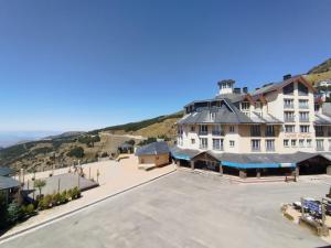 een groot wit gebouw met een heuvel op de achtergrond bij Dornajo Elite in Sierra Nevada