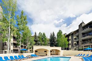 a pool at a resort with chairs and a building at Beaver Creek West 22 in Avon