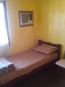 a small bedroom with a bed and a window at Casa en Obera in Oberá