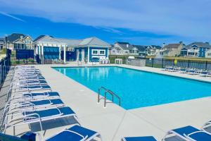 a swimming pool with lounge chairs in front of houses at Marlin Chase in Ocean View
