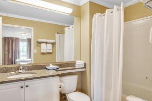 a bathroom with a toilet and a sink and a shower at Little River Resort in Pinehurst +2 photos