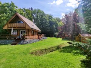 a log cabin in the woods with a large yard at Ferienhaus Birkholz Harz in Altenrode