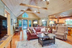 a living room with a red couch and a table at Hot Tub, Decks and Creek Access McCaysville Cabin! in McCaysville