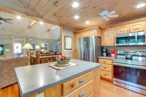 a kitchen with wooden cabinets and a counter top at Hot Tub, Decks and Creek Access McCaysville Cabin! in McCaysville