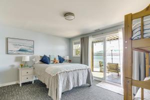 a bedroom with a bed and a view of the ocean at Bayfront Home with Private Beach in Poulsbo! in Poulsbo