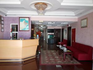 a lobby with a red couch and a bar at Azaiba Hotel Apartments in Muscat