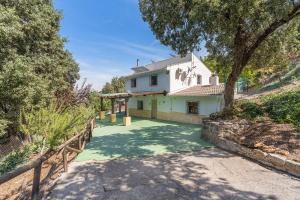 einen Blick auf ein weißes Haus mit einem Zaun in der Unterkunft Cortijo Las Chorreras Illora in Puerto-López