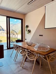 a dining room with a wooden table and chairs at Alpine Escape Kazbegi in Kazbegi +40 photos