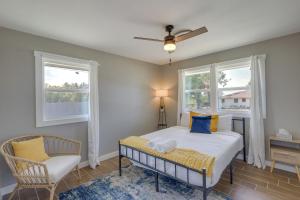 a bedroom with a bed and a chair and two windows at Temple Family Home 4 Mi to Dtwn! in Temple