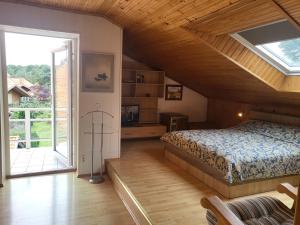 a bedroom with a bed and a large window at House Violeta in Nida