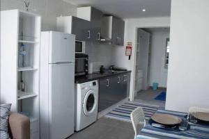 a kitchen with a refrigerator and a washing machine at Aligus 1 Apartamento na Horta, Faial, Açores in Horta