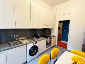 een keuken met witte kasten en een wasmachine bij CityLife & Fiera Milano Apartment with AC, WiFi, Metro M1 and Airport link in Milaan +9 foto's
