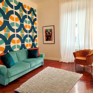 een woonkamer met een blauwe bank en een geometrische muur bij CityLife & Fiera Milano Apartment with AC, WiFi, Metro M1 and Airport link in Milaan