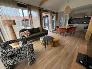una sala de estar con un sofá y una mesa en La Casita, Luxe Chalet Aan Het Water met Airco, en Anjum 9 fotos más