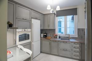 a kitchen with white cabinets and a white refrigerator at To Spitaki in Thessaloniki