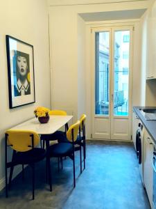 een keuken met een tafel met gele stoelen en een raam bij CityLife & Fiera Milano Apartment with AC, WiFi, Metro M1 and Airport link in Milaan