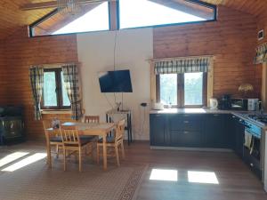 Una cocina y un comedor con mesa y sillas. en Cabana Laura, en Tîrnăveni 21 fotos más