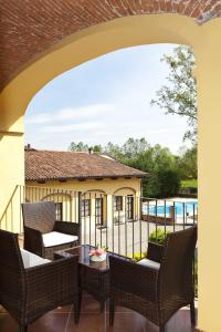 un patio con sillas, una mesa y una piscina en Villa Soleil, en Colleretto Giacosa