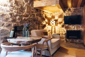 a living room with a table and a stone wall at Story Studio Sortelha - Heritage in Sortelha