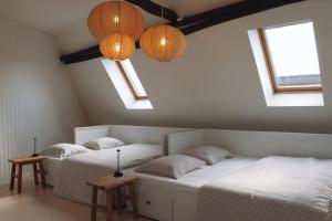 two beds in a room with two windows and lights at Vakantiehuis Ellezelles in Ellezelles +38 photos
