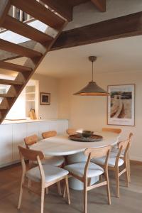 a dining room with a white table and chairs at Vakantiehuis Ellezelles in Ellezelles