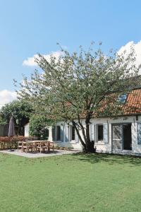 a table and a tree in front of a house at Vakantiehuis Ellezelles in Ellezelles