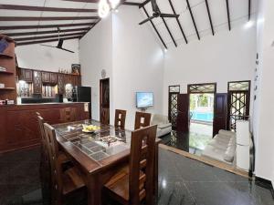 een keuken en eetkamer met een tafel en stoelen bij Bora Bora Villa in Hikkaduwa