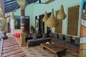 een woonkamer met een bank en een tafel bij Bora Bora Villa in Hikkaduwa