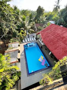 een uitzicht over een zwembad met een rood dak bij Bora Bora Villa in Hikkaduwa
