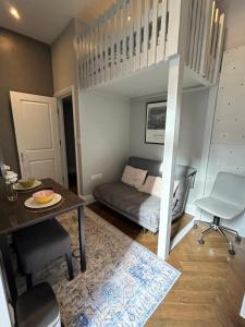 a bedroom with a bunk bed and a desk and a table at Chelsea flat, convenient and quiet in London