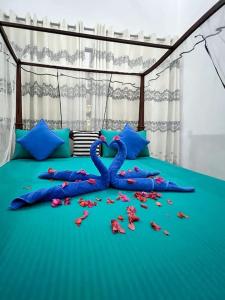 een bed met een blauw dekbed met bloemen erop bij Bora Bora Villa in Hikkaduwa +22 foto's