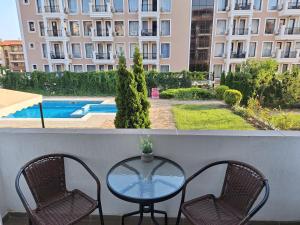 a table and chairs on a balcony with a view of a building at Studio Anelia in Sveti Vlas