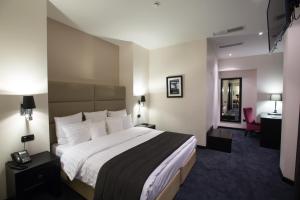 a hotel room with a bed and a desk at North Avenue by Stellar Hotels, Yerevan in Yerevan