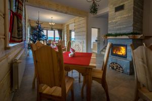 a dining room with a table and a fireplace at Gościna Na Wierchu Murzasichle in Murzasichle