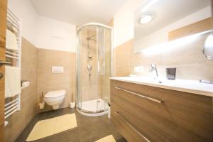 a bathroom with a shower and a toilet and a sink at Residence Alpin in Zell am Ziller