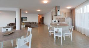 a kitchen and living room with a table and chairs at Silver Beach Apart Complex in Byala