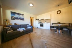 a living room with a couch and a kitchen at Residence Alpin in Zell am Ziller