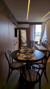 a dining room table with chairs and a room with a couch at Vista Azul Apart Hotel - Vista Pedra Azul in Pedra Azul