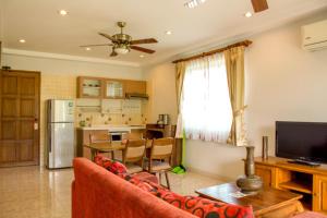 a living room with a couch and a kitchen at Baan Rosa Bangtao Beach in Bang Tao Beach