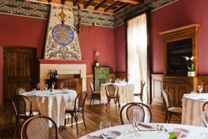 a dining room with tables and chairs and a fireplace at Villa Soleil in Colleretto Giacosa