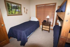 a bedroom with a blue bed and a nightstand and a bed sidx sidx sidx at Stemwinder 5 Spacious Townhome Short Distance to Powder Monkey Lift in Snowshoe