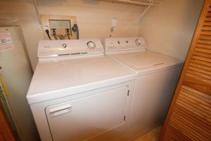a small kitchen with two white washer and dryer at Stemwinder 5 Spacious Townhome Short Distance to Powder Monkey Lift in Snowshoe +58 photos