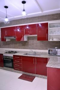 a kitchen with red cabinets and a sink at Appartement duplex très chic in Ville Nouvelle