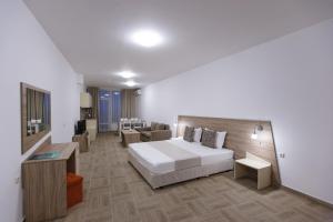 a hotel room with a bed and a couch at Silver Beach Apart Complex in Byala +76 photos