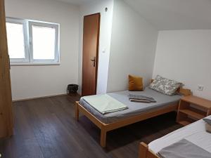 a small room with a bed and a window at Prenoćište Lipov lad in Negotin