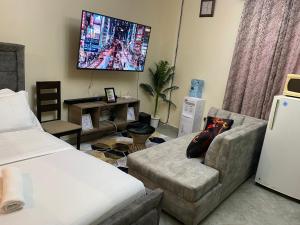 a living room with a couch and a tv at Emerald in Ruaka