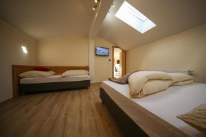 two beds in a small room with a skylight at Residence Alpin in Zell am Ziller