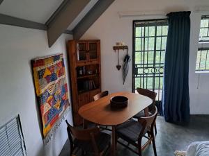 una sala da pranzo con tavolo, sedie e una finestra di Casa Mana Air B&B a Pretoria