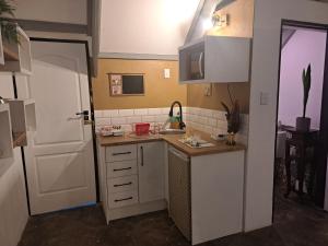 una piccola cucina con lavandino e porta bianca di Casa Mana Air B&B a Pretoria Altre 8 foto