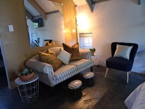 un soggiorno con un divano e una poltrona di Casa Mana Air B&B a Pretoria